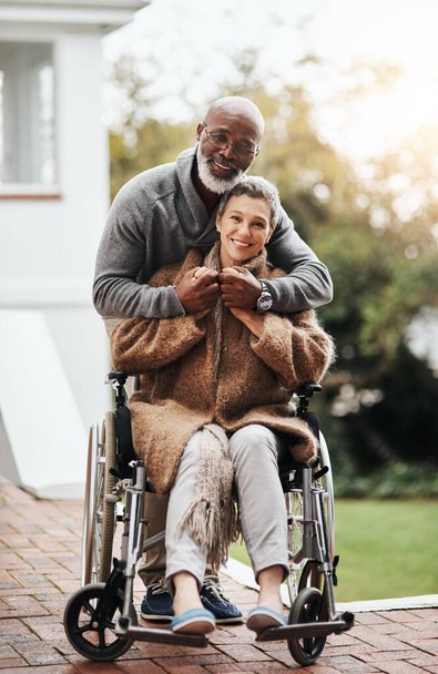 Наше кохання залишається сильним. літній чоловік штовхає свою дружину на інвалідному візку навколо двору вдома
 - Фото, зображення
