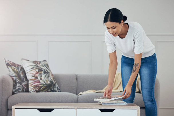 Cleaning, living room books and hygiene woman tidy apartment, home or desk table surface for domestic housework. Magazine, maid service and casual house cleaner working, housekeeping or doing chores. - Foto, Imagen