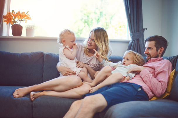 The most important time there is. an adorable young family of four relaxing together on the sofa at home - Fotó, kép