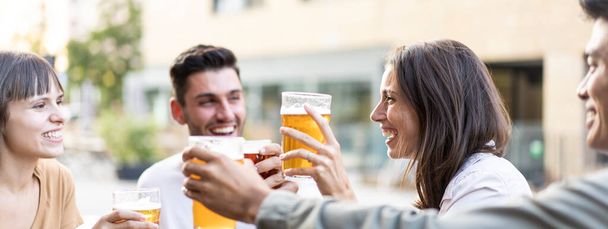 Горизонтальний банер або заголовок з багаторасовими друзями, які п'ють пиво в пабі - справжня концепція життя дружби з хлопцями та дівчатами, насолоджуючись щасливою погодинною їжею у барі на відкритому повітрі
 - Фото, зображення