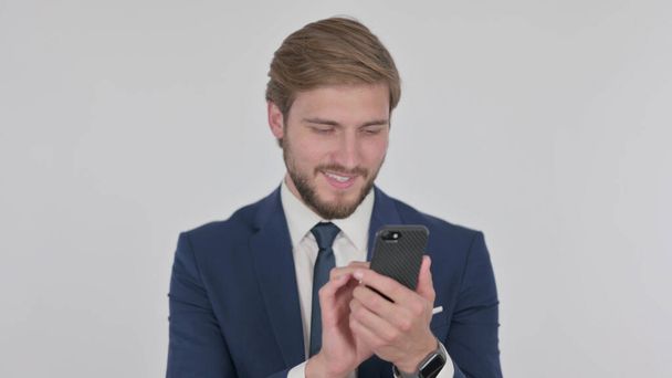 Young Adult Businessman Browsing Smartphone on White Background - Photo, image