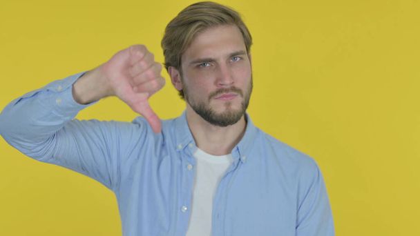Thumbs Down by Casual Young Man on Yellow Background - Photo, Image