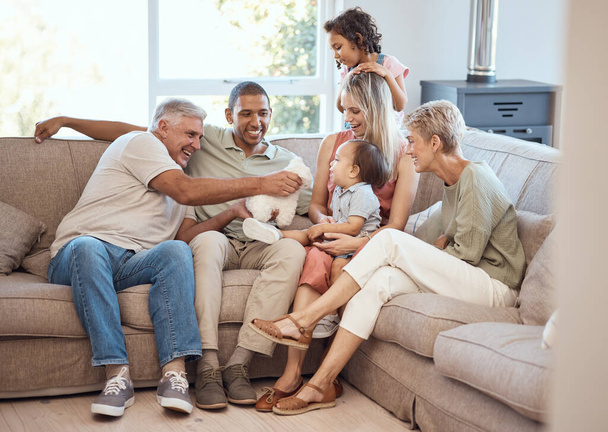 Happy, love and big family relaxing on sofa together in the living room of their house. Happiness, grandparents and parents with children playing, bonding and resting in lounge of their modern home - Photo, image