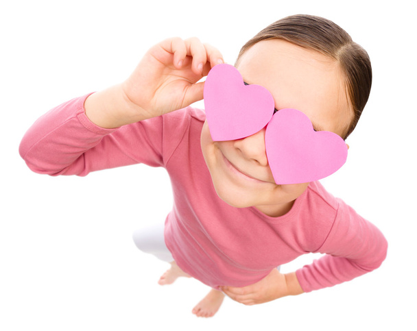 Little girl is holding hearts over her eyes - Zdjęcie, obraz