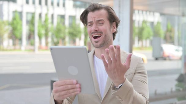 Upset Man Reacting to Loss on Tablet Outdoor - Fotografie, Obrázek