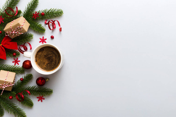 Heerlijke verse feestelijke ochtendkoffie in een keramisch kopje met kleine cadeautjes, ornament en kerstspeelgoed. Kopje koffie en nieuwjaarsspeelgoed. - Foto, afbeelding