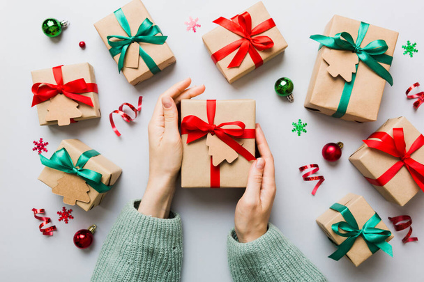 Жінка тримає коробку з подарунками, готуючи сюрприз для відпочинку, зверху, Різдво та Новий рік.. - Фото, зображення