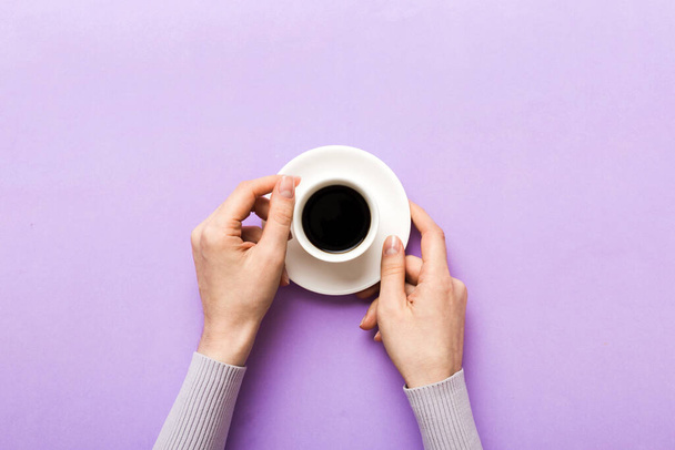 Minimalistischer Stil Frau Hand hält eine Tasse Kaffee auf farbigem Hintergrund. Flache Lage, Cappuccino-Tasse von oben. Leerer Platz für Text, Kopierraum. Kaffeesüchtig. Draufsicht, flache Lage. - Foto, Bild