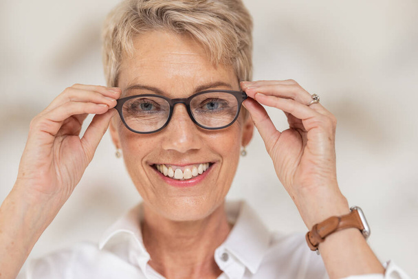 Mature woman, face and vision glasses in fashion or style eye care for healthcare insurance, medical wellness or glaucoma support. Smile portrait, happy person and optometry prescription eyes lenses. - Foto, Imagem