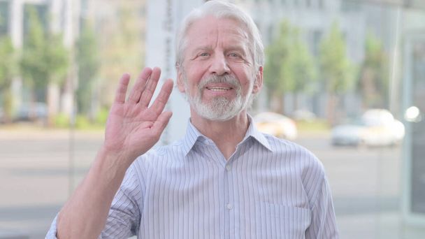 Welcoming Senior Old Man Waving Hand for Hello Outdoor - 写真・画像