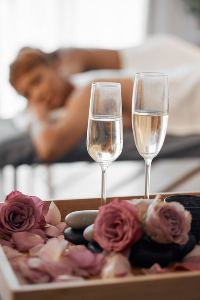 Champagne, massage and couple relax together for a anniversary, love and calm spa experience. Wellness, alcohol with flowers and luxury physical therapy activity of man and woman for romance and rest. - Foto, Bild