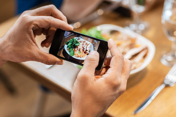 technology and people concept - close up of man with smartphone photographing food at restaurant - Foto, imagen