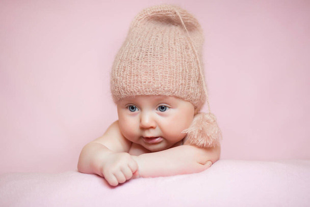 Jeugd, zorg, moederschap, gezondheid, geneeskunde, pediatrie concepten - Close up Weinig vrede rustig naakt pasgeboren baby meisje met roze hoed slaapt rust nemen diepe dutje liggend op buik op zacht bed - Foto, afbeelding