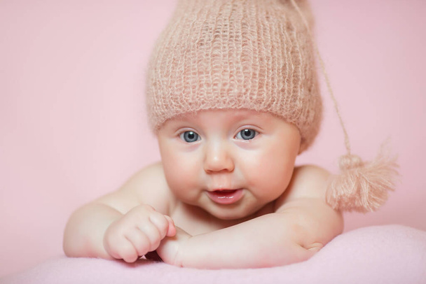 Jeugd, zorg, moederschap, gezondheid, geneeskunde, pediatrie concepten - Close up Weinig vrede rustig naakt pasgeboren baby meisje met roze hoed slaapt rust nemen diepe dutje liggend op buik op zacht bed - Foto, afbeelding
