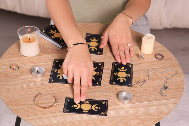 Soothsayer predicting future with tarot cards at table indoors, closeup - Фото, изображение