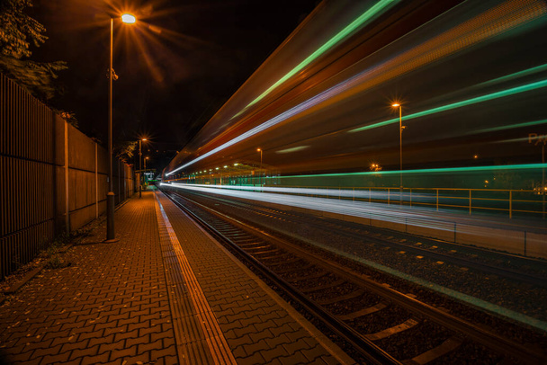 Railway track and train light in night in Prague Podbaba color station - Photo, Image