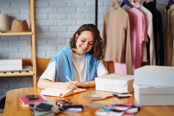 Small business owner, entrepreneur, seller  checking ecommerce clothing store orders  working in her office. Online sales. - 写真・画像
