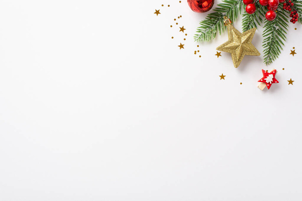 Weihnachtstag. Foto von oben Tannenzweig dekoriert mit roter Christbaumkugel goldenen Stern Ornament Mistelbeeren dekorative Clip und glänzende Konfetti auf isoliertem weißen Hintergrund mit leeren Raum - Foto, Bild