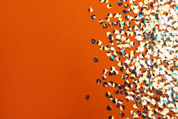 Shiny bright glitter on orange background, flat lay. Space for text - Valokuva, kuva