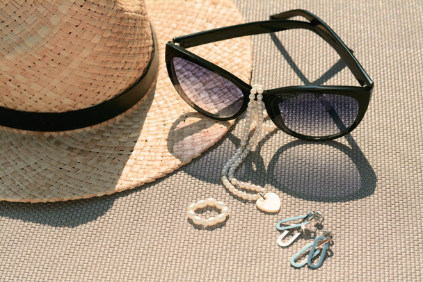 Stylish hat, sunglasses and jewelry on grey surface, closeup - Foto, Imagem