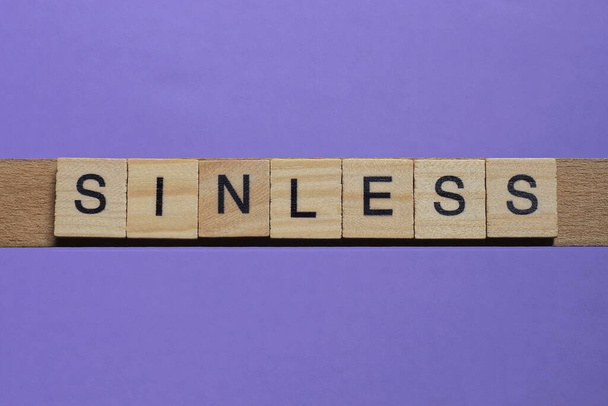 mot sans péché fabriqué à partir de lettres grises en bois repose sur un fond lilas - Photo, image