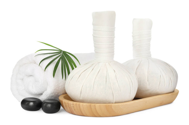 Herbal massage bags, spa stones, towel and green leaf on white background - Zdjęcie, obraz