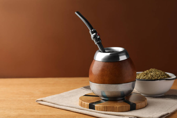 Calabash with mate tea and bombilla on wooden table. Space for text - Foto, Imagem