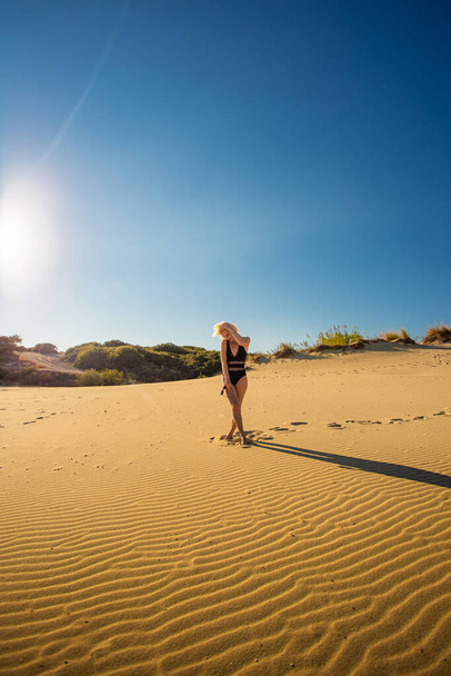 young woman walking on sandy dunes in desert - Photo, image
