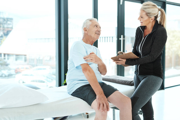 Sežene pomoc, kterou potřebuje. starší muž konzultuje se svým fyzioterapeutem v její kanceláři - Fotografie, Obrázek