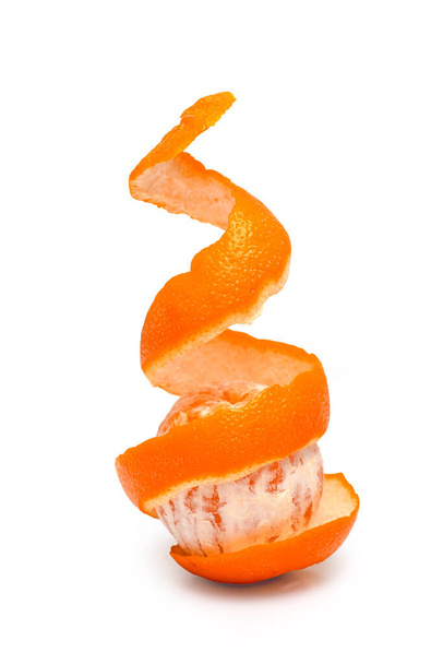 Kabuğu soyulmuş turuncu bir fotoğraf, beyaz bir arkaplanda spiral şeklinde. Sağlıklı yaşam tarzı kavramı. - Fotoğraf, Görsel