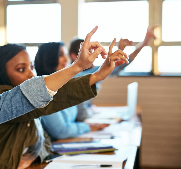Ellos tienen preguntas. un grupo de estudiantes universitarios sentados con las manos en alto en clase - Foto, Imagen
