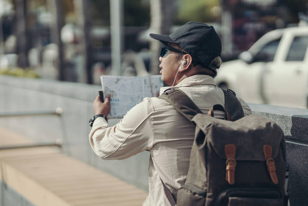 Tourists hold maps to find attractions, restaurants or hotels. backpacker and travel concept. - Foto, Imagem