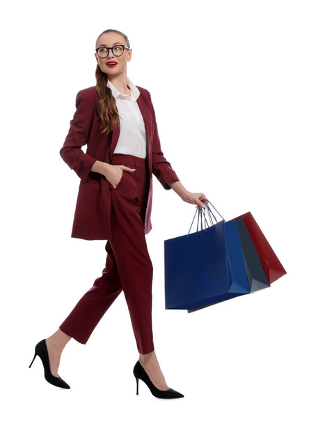 Stylish young businesswoman with shopping bags on white background - Photo, image