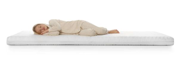Little girl sleeping on comfortable mattress against white background - Foto, imagen