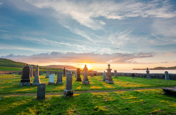 Magiczny zabytek historyczny w pobliżu Durness, założony 8 wieku, ważny celtycki klasztor, starożytne nagrobki i cmentarz, trawa pokryta, dramatyczne niebo zachód słońca, w Balnakeil Bay, niesamowita atmosfera o zmierzchu. - Zdjęcie, obraz