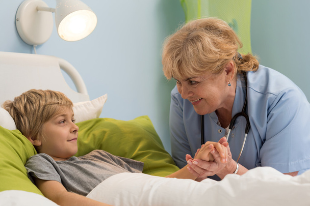 Pediatrician holding hand of her patient - Valokuva, kuva