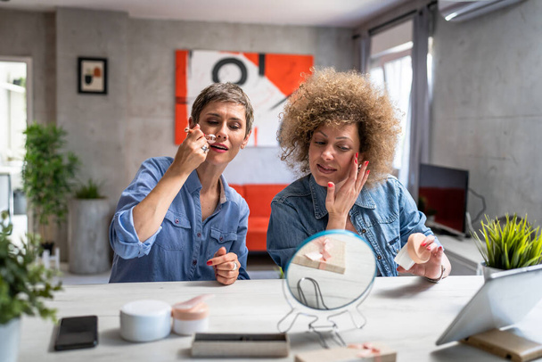 dvě ženy dospělé a starší ženy přátelé pomocí kosmetické a péče o pleť produkty gua sha nefritové masáže obličeje válec skuteční lidé kopírovat prostor doma - Fotografie, Obrázek