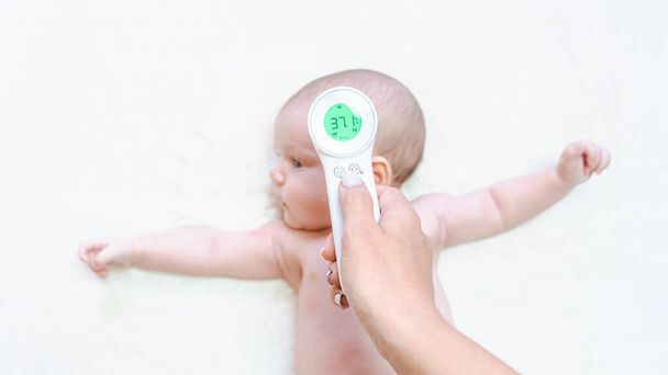 体温計の子供熱。医者は電子温度計から冷たいインフルエンザの赤ん坊の温度ケアを点検する。子供の病気、子供の健康管理、インフルエンザの温度背景 - 写真・画像