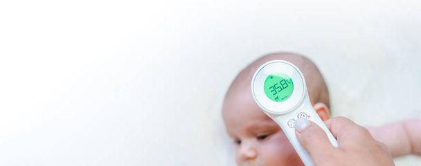 Ηλεκτρονικό θερμομετρικό πανό για παιδιά. Γιατρός ελέγξτε κρύο γρίπη φροντίδα της θερμοκρασίας του μωρού από το ηλεκτρονικό θερμόμετρο. Πυρετός μωρό, φροντίδα της υγείας του παιδιού, άρρωστο παιδί φόντο - Φωτογραφία, εικόνα