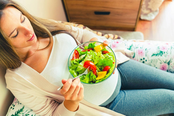 Вагітність їсть здоровий салат. Щаслива вагітна жінка їсть їжу. Люди стиль життя концепція їжі
 - Фото, зображення