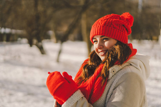 A beautiful woman in winter clothes is enjoying the winter. Christmas and New Year celebration concept. - Photo, Image