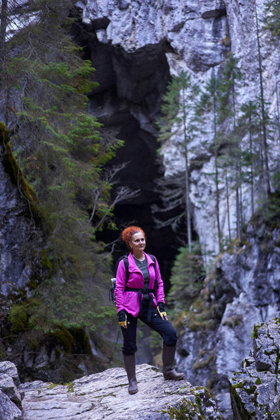 Woman hiker with backpack on a hiking trail in the mountains - Foto, afbeelding
