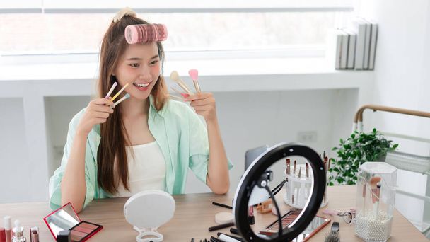 Beauty Influencer Konzept, junge Frau präsentieren verschiedene Make-up-Pinsel und stellen Produkt auf Vlog vor. - Foto, Bild