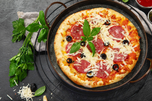 Freshly baked pepperoni pizza on dark background. Tasty homemade food concept. Top view, copy space - Fotoğraf, Görsel