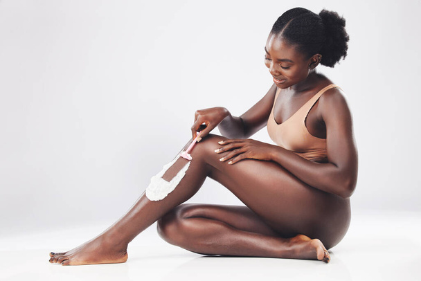 Περιποίηση ποδιών, αποτρίχωση κρέμας ξυρίσματος και μαύρη γυναίκα μοντέλο απασχολημένος με την υγιεινή του σώματος και τον καθαρισμό του δέρματος. Ομορφιά, καλλυντικά και ευεξία ενός ατόμου από την Κένυα ξύρισμα και φροντίδα με λοσιόν και σαπούνι. - Φωτογραφία, εικόνα