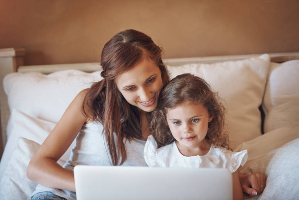 Tekniikka tekee oppimisesta mielenkiintoisempaa ja hauskempaa. äiti ja hänen pieni tyttärensä käyttävät läppäriä yhdessä kotona - Valokuva, kuva