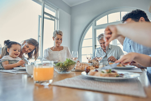 Eating food together, lunch and happy family bonding, having fun and enjoy quality time in home dining room. Love, happiness and big family of hungry grandparents, parents and child eat brunch buffet. - Photo, Image
