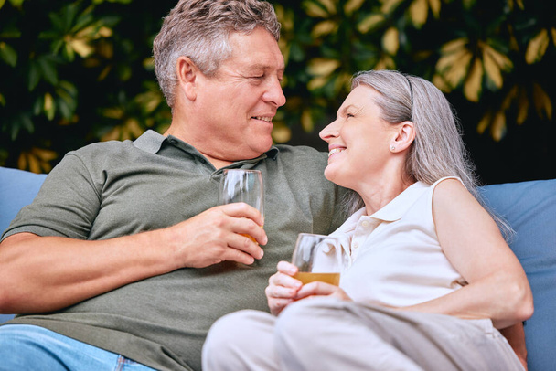 Senior couple, drink and relax while on retirement, love and happy together on vacation and outdoor. Elderly, man and woman enjoy retirement, romantic and care in relationship with relaxing lifestyle. - Photo, Image