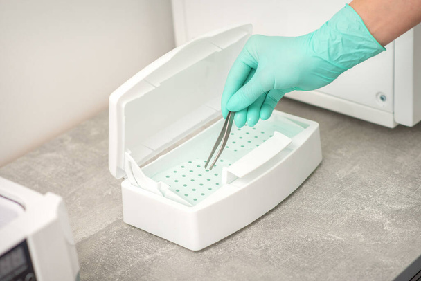 Hand disinfects tweezers with cleaning systems for medical instruments. Ultrasonic cleaner - Φωτογραφία, εικόνα