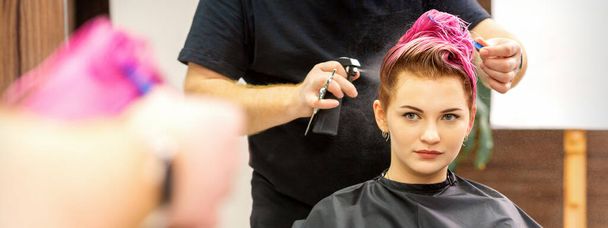 Красивая молодая розововолосая белая женщина в современной парикмахерской - Фото, изображение